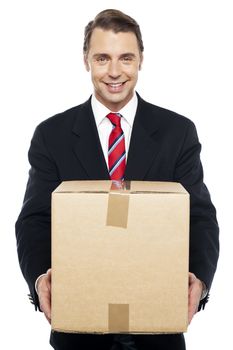 Smiling businessman holding cardboard box, being asked to change his cube