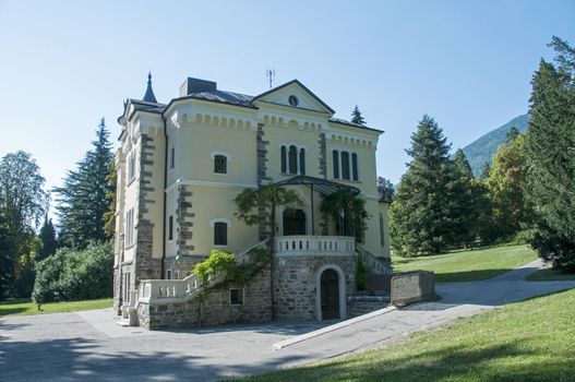 big building in Italy in the place Levico Terme with green trees and grass around
