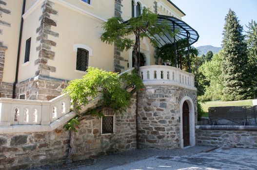 entrance of a big house in Italy with stairs and green plants