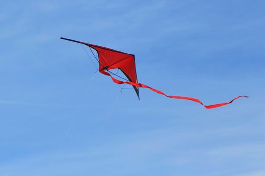 Big red kite flying in the blue sky