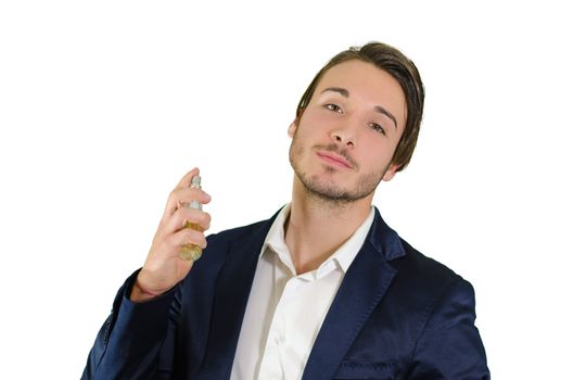 Handsome young man spraying perfume, using fragrance or cologne