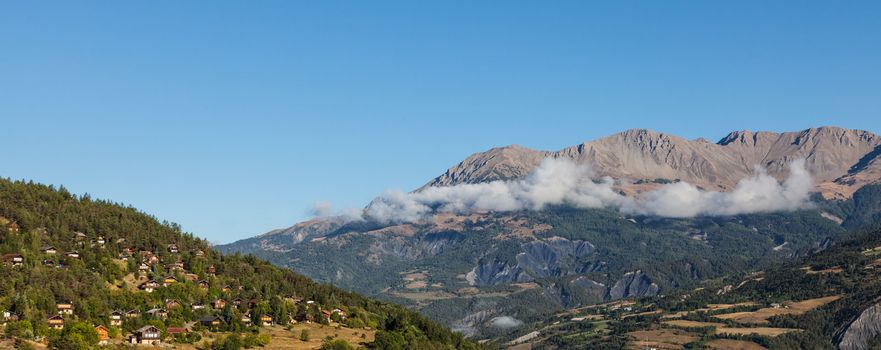 Image of a village located on a high altitude slope with forest in The Southern French Alps in Alpes-de-Haute-Provence region.