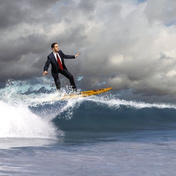 Image of young business person surfing on the waves of the ocean