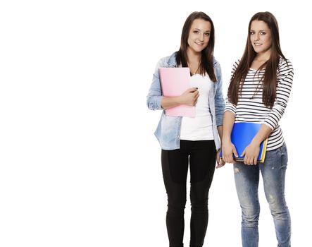 portrait of two pretty student teenagers with note pads on white background