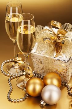 two glasses of champagne with christmas present and christmas balls