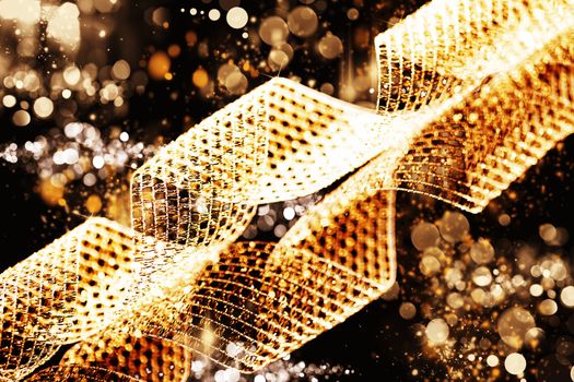golden metal ribbon background or texture with abstract golden sparkling lights