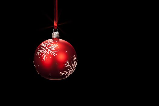 hanging red dull christmas ball on black background
