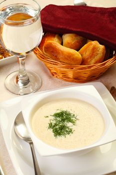 restaurant cream soup with bread and water glass