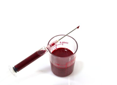Needle of syringe with blood drop. Isolated over white