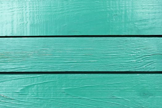 Fragment of wooden fence painted in bright aquamarine