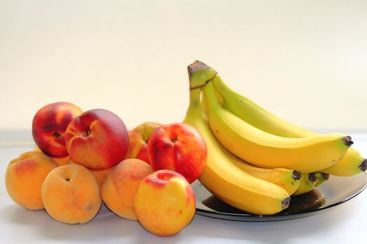 beautiful, delicious peaches, bananas on a light background