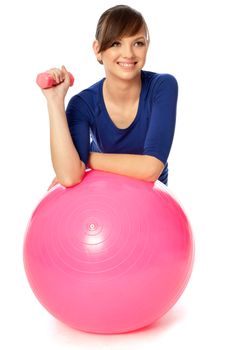 instructor showing exercises using ball and dumbbells at gym to people