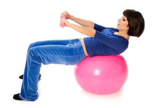 instructor showing exercises using ball and dumbbells at gym to people