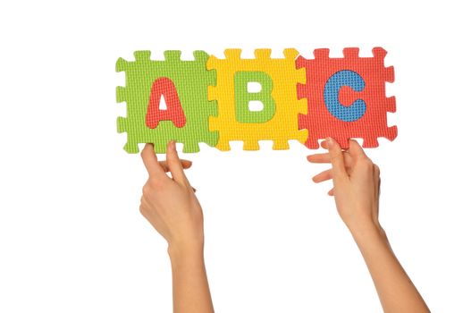 Teacher holding in the hand the amusing colored educational puzzles with alphabet
