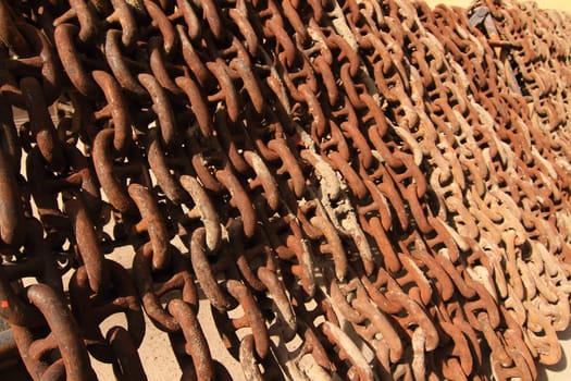Old rusty ship anchor chain links close up.