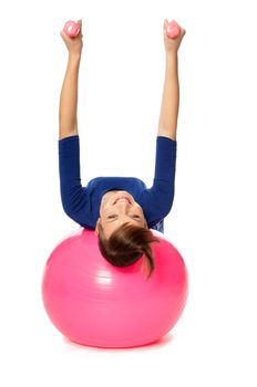 Instructor taking exercise class using ball and dumbbells at gym