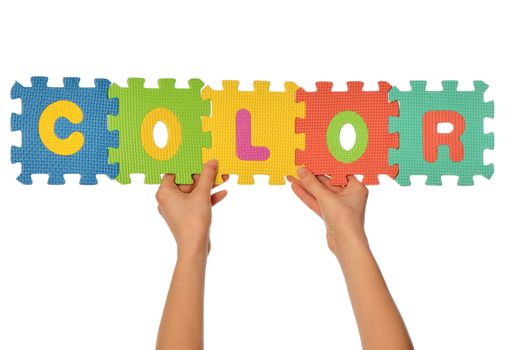 teacher holding in the hand the amusing colored educational puzzles with the word color