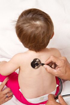 Children's doctor exams infant with stethoscope 