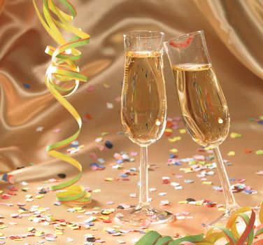 party background with filled champagne glasses in floating satin back with streamers and confetti