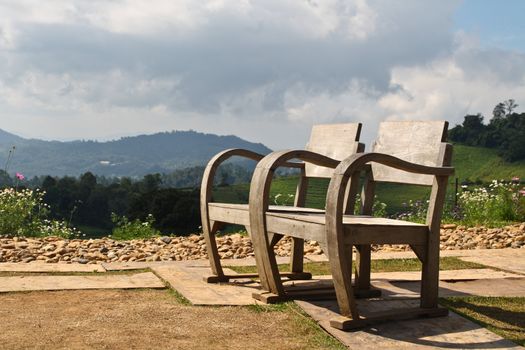 A pair of wooden chairs. High mountains in the park, I love it.