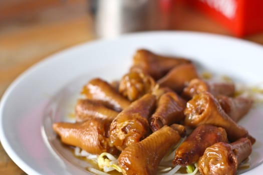 Stewed chicken leg with bean sprouts on a white plate.