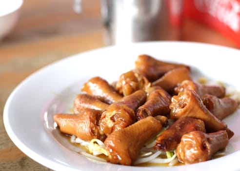 Stewed chicken leg with bean sprouts on a white plate.