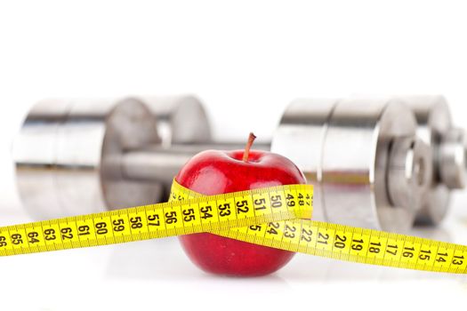 Dumbbells with an apple on a white background
