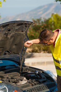 Male making sure his engine is ok for oil