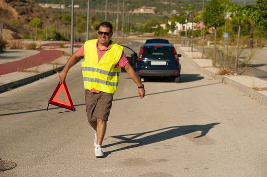 Guy carrying a triangle to warn of his breakdown