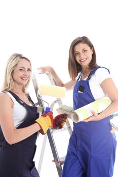 Happy home decor team of two smiling female friends in overalls about to embark on a wallpapering project 