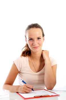 Pretty young woman sitting at a white table with a clipboard and sheet of paper in front of her writing notes Pretty young woman sitting at a white table with a clipboard and sheet of paper in front of her writing nites 