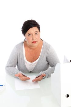High angle view of a middle-aged woman seated at a table with a sheet of paper in front of her pleading her case High angle view of a middle-aged woman seated at a table with a sheet of paper in front of her pleading her case