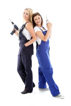 Two DIY women friends standing back to back holding handheld power tools as they smile cheerfully at the prospect of their next project 