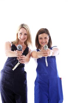 Humorous image of two attractive women artisans having fun taking aim at the camera with their handheld power tools 