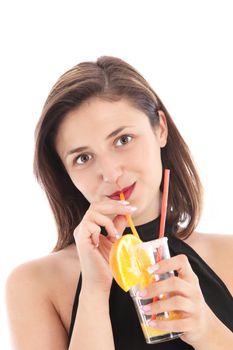 Attractive woman in a black halter neck drinking a tall glass of tropical orange juice or cocktail isolated on white Attractive woman in a black halter neck drinking a tall glass of tropical orange juice or coctail