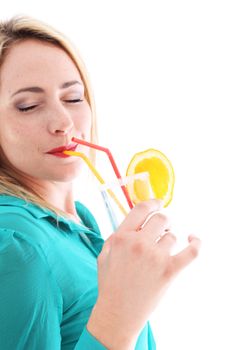 Blissful woman in a turquoise top drinking orange cocktail with her eyes closed as she savours every last drop on her summer vacation 