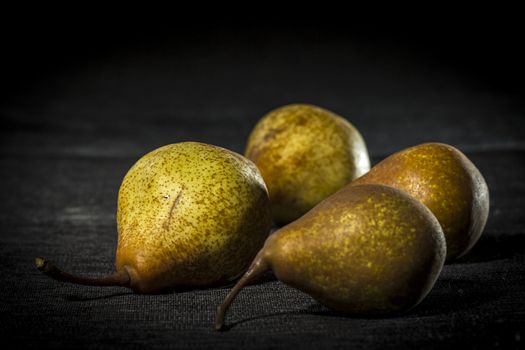 Organic pears on dark background, dramatic lights