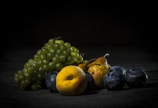 Organic fruits on dark background, dramatic lights