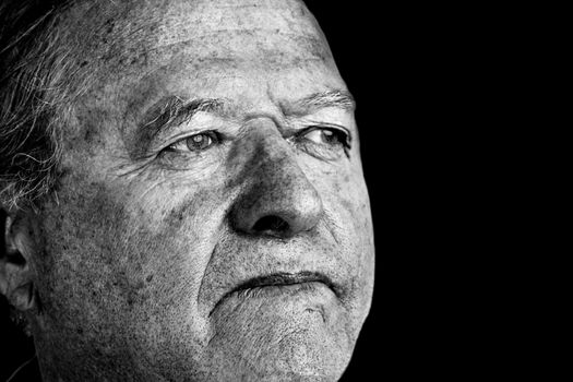 Dramatic and powerful black and white portrait of a senior man with pale eyes looking away great facial details, perfect for aging or other old age issues.