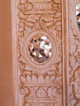 Closeup of white stucco and mirror decoration in the interior wall of historic old house in Kashan, Iran