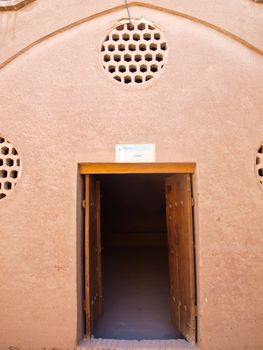 Ventilation Louver and wooden door in the adobe architecture of kitchen in historic old house in Kashan, Iran