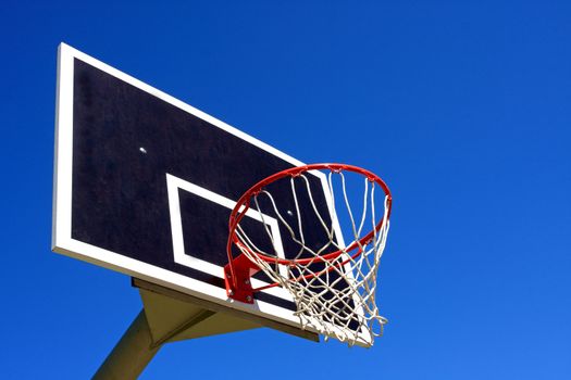 Basketball hoop against bright blue sky