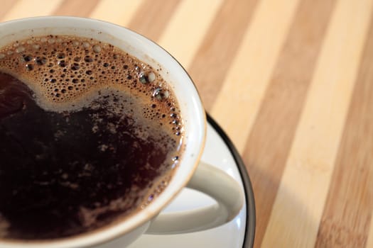 Coffee on cup on striped table 