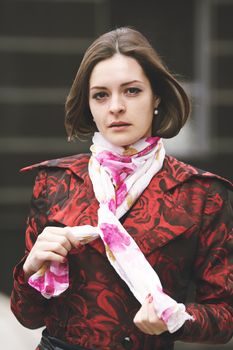 Beautiful girl in a red coat on a black granite.