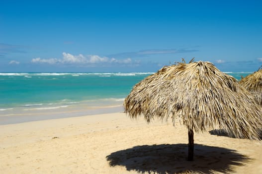 Parasol made out of palm leafs on exotic beach. Dominican Republic, Punta Cana.