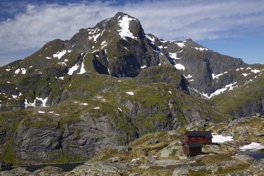 Picturesque mountain hut below the mountain of Munkebu with the highest peak on western Lofoten, Hermannsdalstinden, in the background