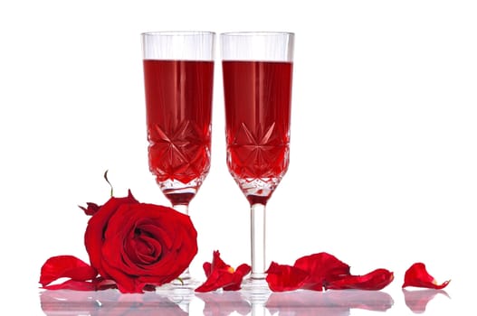 two tumblers with red wine and red rose on the party