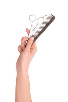 Scissors and comb in the hand on white background