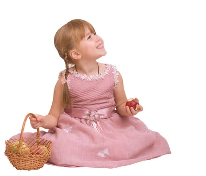 little girl sitting with basket and eating an apple on white background