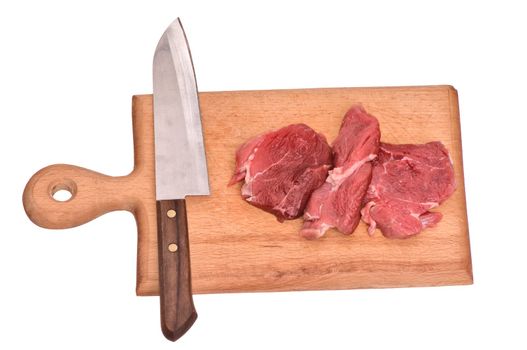 Slices of the meat on the board with knife on the kitchen